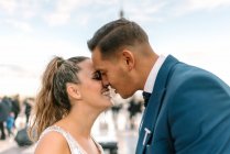 Brilho em terno azul e noiva em vestido de casamento branco beijando apaixonadamente com Torre Eiffel no fundo em Paris — Fotografia de Stock