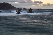 Pictuosas y majestuosas aguas de la bahía rompiendo rocas en la playa de Silence O Gaviero en España. - foto de stock