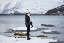 Joven asiático mujer en estanque orilla contra highland en invierno - foto de stock