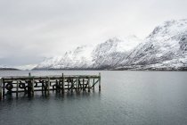 Muelle de madera en medio de un lago tranquilo en invierno - foto de stock