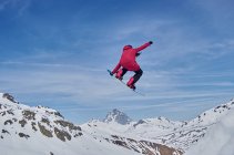 Snowboarder irreconocible saltando en la pendiente - foto de stock