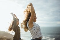 Счастливые женщины-путешественницы наслаждаются свободой на море — стоковое фото