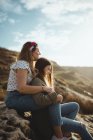 Young sisters sitting on stone on spring day — Stock Photo