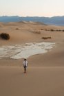 Uomo solitario che cammina nel deserto sabbioso — Foto stock