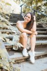 Stylish woman sitting on stairs of park in New York — Stock Photo