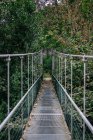 Висячий металлический мост через кустарник — стоковое фото