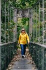 Весела жінка - туристка, що стоїть на висячому мосту влітку. — стокове фото
