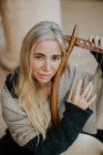 Сверху вдохновила очаровательная женщина с светлыми волосами наслаждаясь музыкой, играя на музыкальном струнном инструменте на террасе — стоковое фото