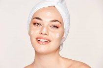 Mulher encantada com pele radiante aplicando creme — Fotografia de Stock