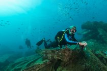 Plongeurs nageant sous-marins explorant les débris — Photo de stock
