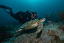 Freier Taucher schwimmt mit großer Schildkröte im Ozean — Stockfoto