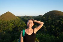 Glückliche Frau steht auf Aussichtsplattform auf Hügel — Stockfoto