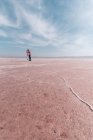 Щасливі спокійні мандрівники насолоджуються незвичайними пейзажами рожевого солоного озера в сонячний день — стокове фото
