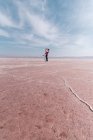 Щасливі спокійні мандрівники насолоджуються незвичайними пейзажами рожевого солоного озера в сонячний день — стокове фото