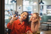 Les jeunes femmes prennent selfie dans un café — Photo de stock