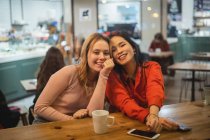 Des amis multiethniques parlent dans un café — Photo de stock