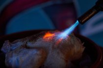 Frisches Hühnchen während der Verarbeitung mit Flammenwerfer mit hellem Gas in Restaurantküche — Stockfoto