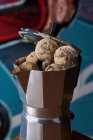 Von oben eine Kaffeemaschine aus rostfreiem Herd mit runden Kugeln köstlicher Schokoladentrüffel, serviert auf einem Tisch gegen eine Wand auf Graffiti — Stockfoto