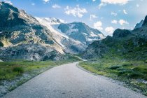 Calm landscape of asphalt paved road curving in mountains with green grass in Switzerland — Stock Photo