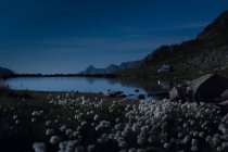 Pedras brancas na margem do lago com água cristalina refletindo céu e montanhas na Suíça — Fotografia de Stock