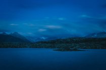 Increíble paisaje de aguas tranquilas en luz azul fría con cordillera en Suiza - foto de stock