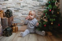 Cute baby playing with Christmas tree baubles — Stock Photo