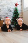 Bebés felices cerca del árbol de Navidad y regalos - foto de stock