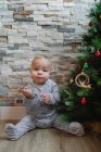 Cute baby playing with Christmas tree baubles — Stock Photo