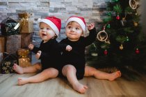 Bébés heureux près de l'arbre de Noël et cadeaux — Photo de stock