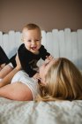 Mother playing with baby on bed — Stock Photo