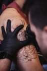 Master doing tattoo on forearm of male customer — Stock Photo