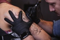 Mestre fazendo tatuagem no antebraço do cliente masculino — Fotografia de Stock