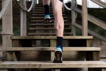 Visão traseira de baixo de homem atleta em roupas esportivas correndo lá em cima — Fotografia de Stock