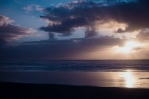 Beau coucher de soleil sur la mer avec ciel nuageux — Photo de stock