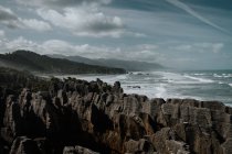 Голубые волны, омывающие скальный берег в яркий день — стоковое фото