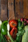 Zusammensetzung von verschiedenen frischen Bio-Gemüsesorten mit grünen Blättern auf rustikalem Holztisch — Stockfoto