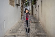 Радісна жінка-туристка в повсякденному одязі серед міської вулиці — стокове фото