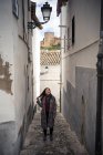 Joyful female tourist in casual wear amid narrow city street — Stock Photo