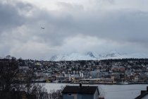 Wunderschönes Stadtbild vor verschneitem Hochland bei kaltem, bewölktem Wetter — Stockfoto
