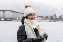 Asiatique touriste femelle en tenue chaude au champ neigeux près de la ville — Photo de stock
