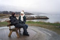 Туристы отдыхают на скамейке на высоте моря — стоковое фото