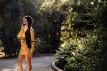 Graciosa morena de cabelos longos Mulher asiática com maçã à luz do sol na estrada do jardim no parque olhando para a câmera — Fotografia de Stock