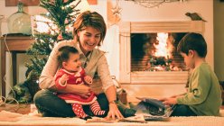 Мати читає книгу з сином напередодні Різдва — стокове фото