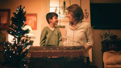 Madre e hijo abren cofre mágico el día de Navidad - foto de stock
