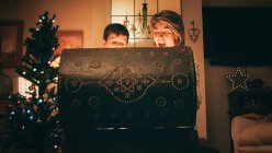 Mutter und Sohn öffnen Zaubertruhe am ersten Weihnachtsfeiertag — Stockfoto