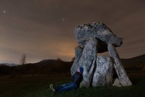 Traveler admiring starry sky near dolmen — Stock Photo