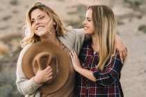 Zwei schöne blonde Frauen kuscheln, als ruhten sie tagsüber in der Wüste — Stockfoto