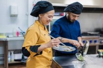 Chef professionisti che preparano piatti nella cucina del ristorante — Foto stock
