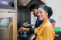 Professional chef and assistant working in kitchen — Stock Photo