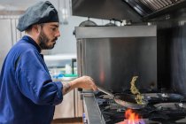 Chef fritando legumes no fogão a gás — Fotografia de Stock